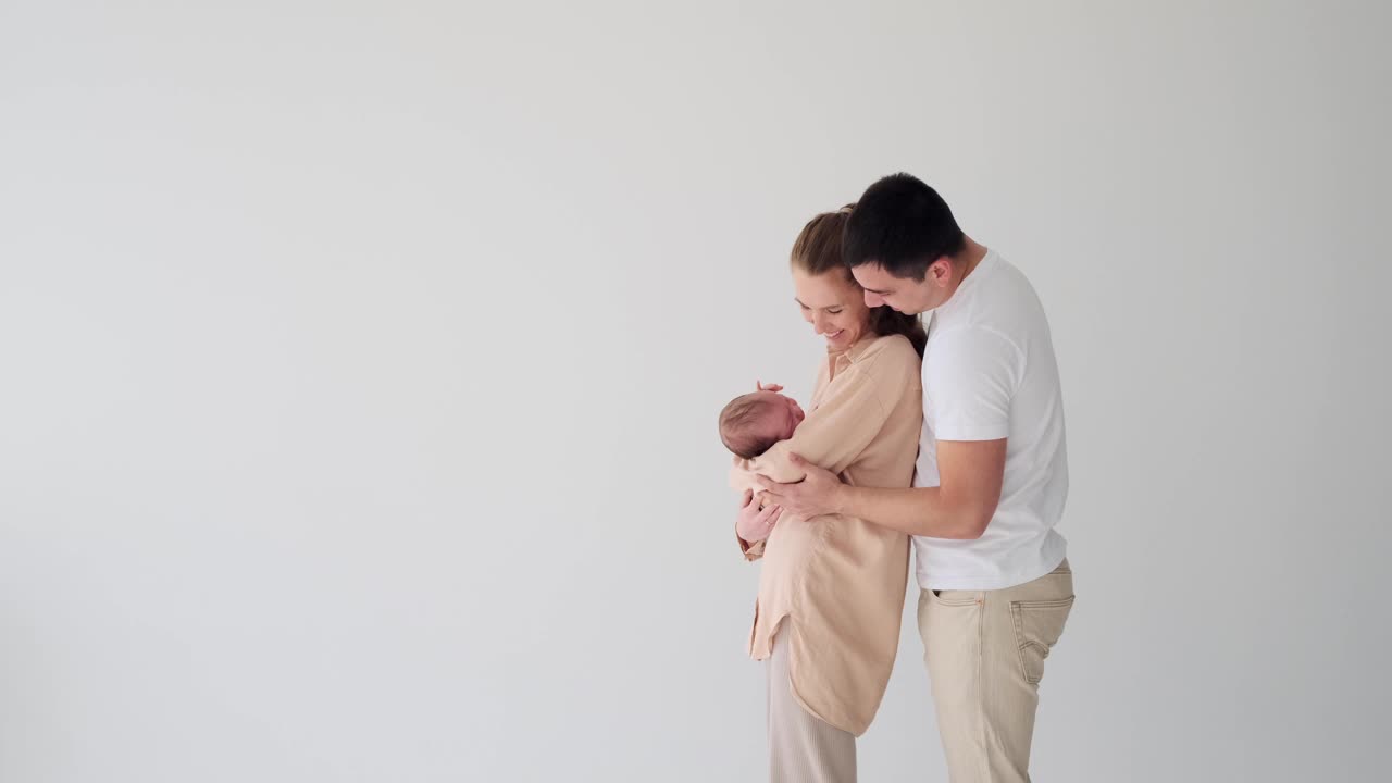 父母抱着并抚摸着他们的宝贝儿子视频下载