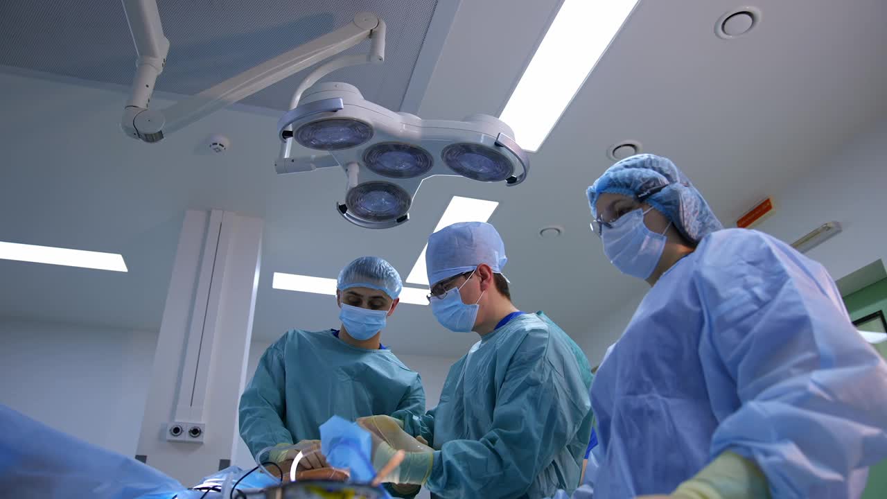 现代临床的外科手术。专科医生在医院里做手术。医生和助手用手术设备进行手术。视频素材
