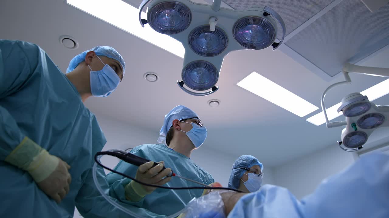 外科医生的医疗灯背景。医生团队合作，在医院进行手术和使用现代医疗设备。视图从下面。视频素材