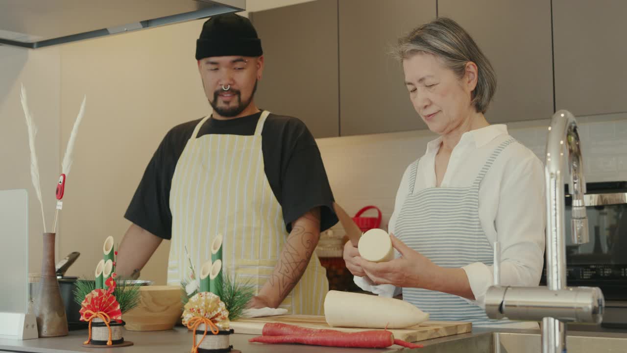 老年妇女和她的成年儿子一起准备传统的日本新年食物视频素材