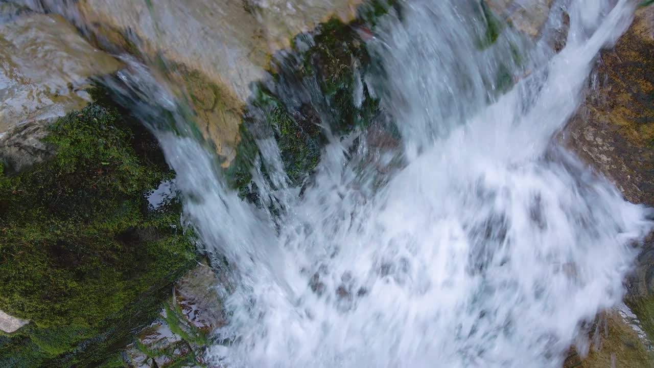 瀑布在山上的河流与白色泡沫水下降下来的岩石形成在夏季森林视频素材