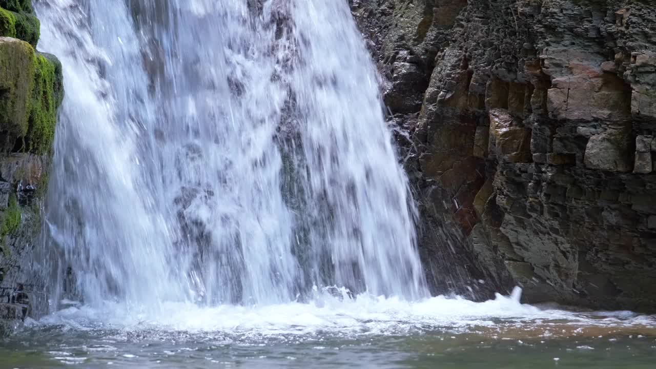 瀑布在山上的河流与白色泡沫水下降下来的岩石形成在夏季森林视频素材