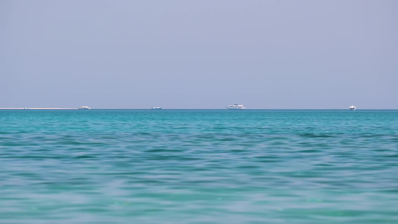海景与波浪表面的蓝色海水与遥远的船只漂浮在平静的波浪视频素材