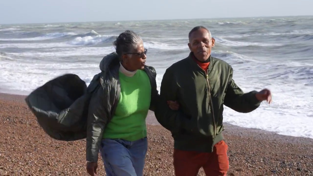 在海滩上散步的老夫妇视频下载