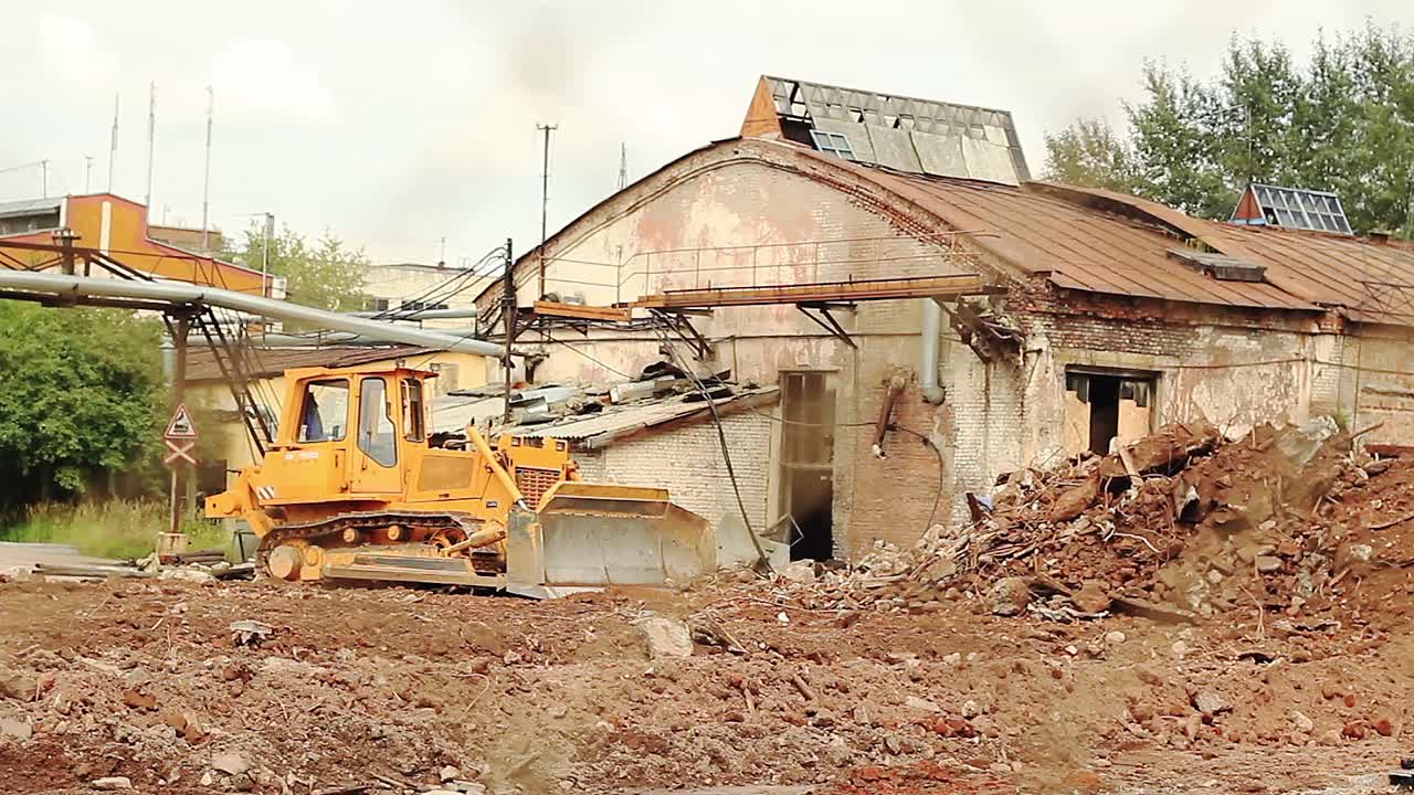重型推土机铲去瓦砾，为新建筑找平地面视频素材