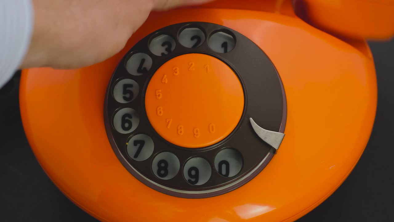 使用老式转盘电话进行拨号。地线概念，橙色电话近视频素材