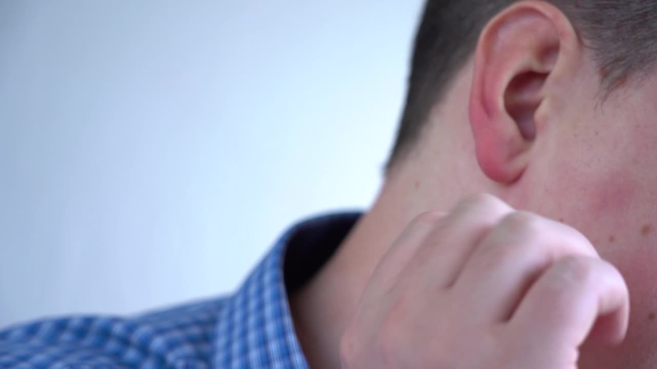 男人搔耳朵。颈部和耳朵的特写。视频素材