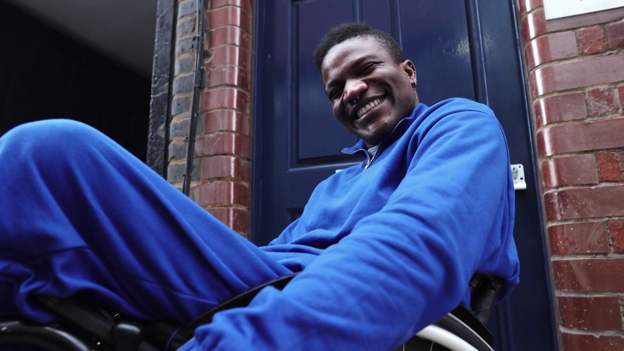 快乐的年轻人穿着蓝色运动服和残疾对着门视频下载
