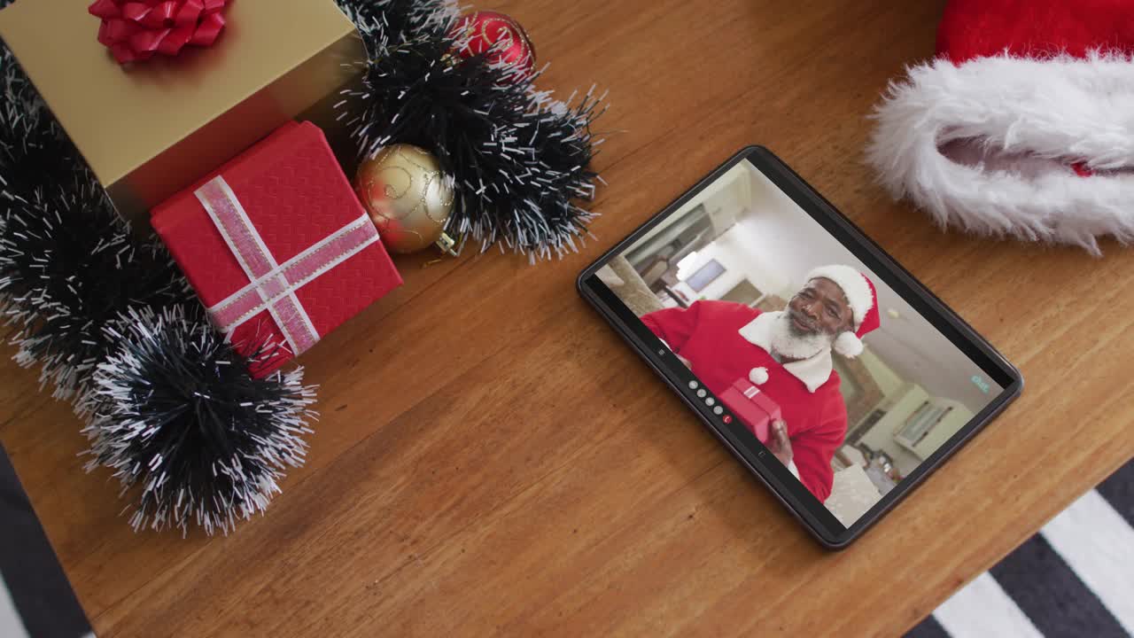 笑容满面的非洲裔美国人穿着圣诞老人服装在平板电脑上进行圣诞视频通话视频下载