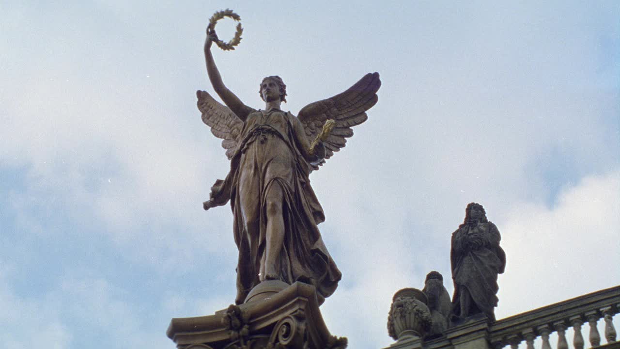 捷克布拉格，高举月桂的天使铜像。其他石像和石栏杆可见在bg。可能是纪念碑的顶端。视频下载