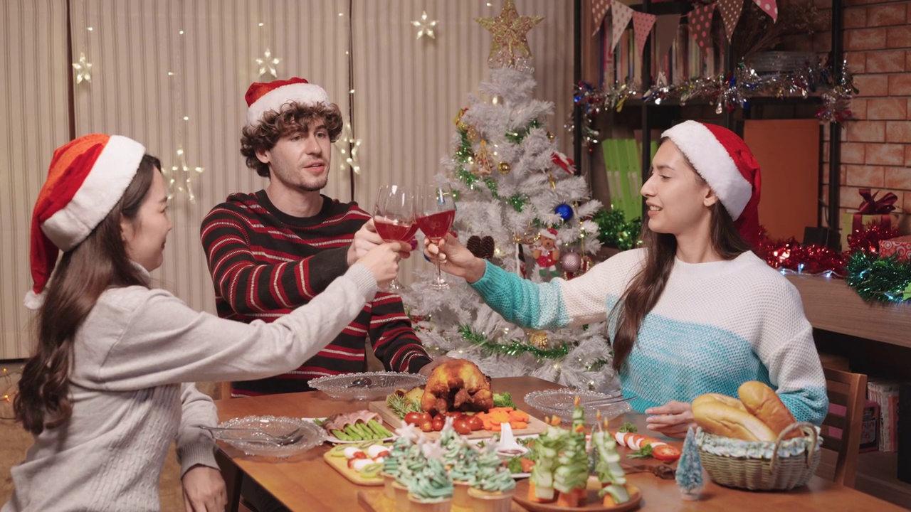 一个年轻的美国年轻男子为两个美丽的亚洲年轻女性在圣诞派对在家里视频素材
