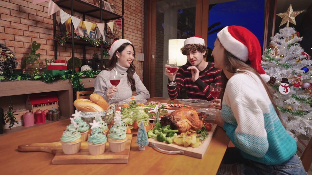一群快乐的年轻多种族朋友戴着圣诞帽，在家中举杯并享受圣诞和节日的生活理念视频素材