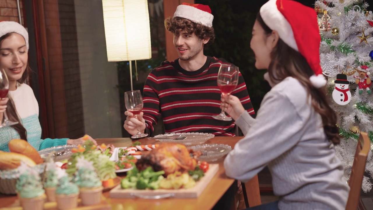 庆祝年轻的多种族朋友在家中欢聚一堂，共饮圣诞美酒视频素材