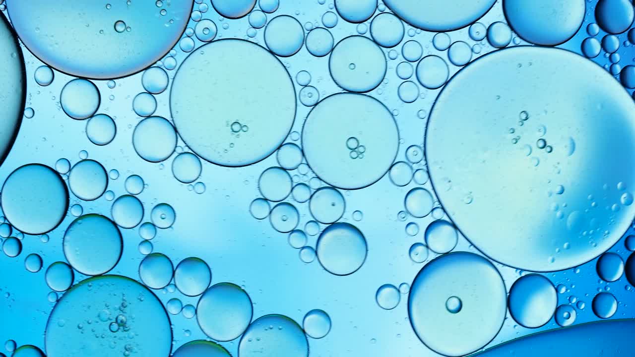 在蓝色背景上移动的液体气泡的完整框架。视频购买
