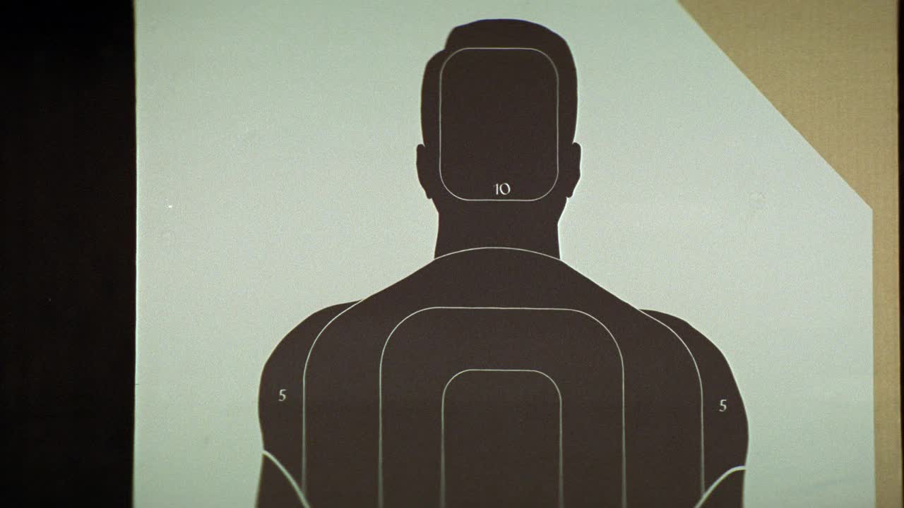 在射击场或射击场中，枪声或枪声对人体轮廓目标的近角度。纸上的弹孔。视频下载
