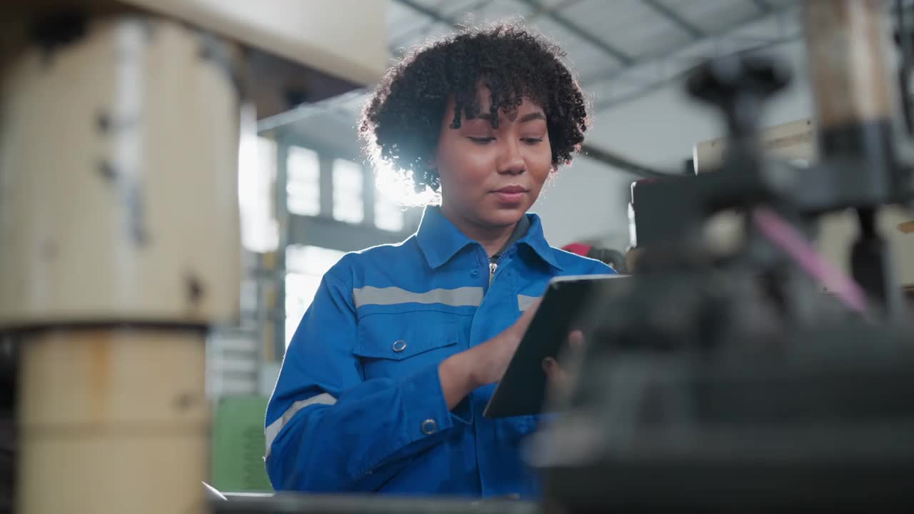 女性非裔美籍机械工程师操作数控铣床的安装过程，女性技术员工作在生产金属产品的进度线视频下载