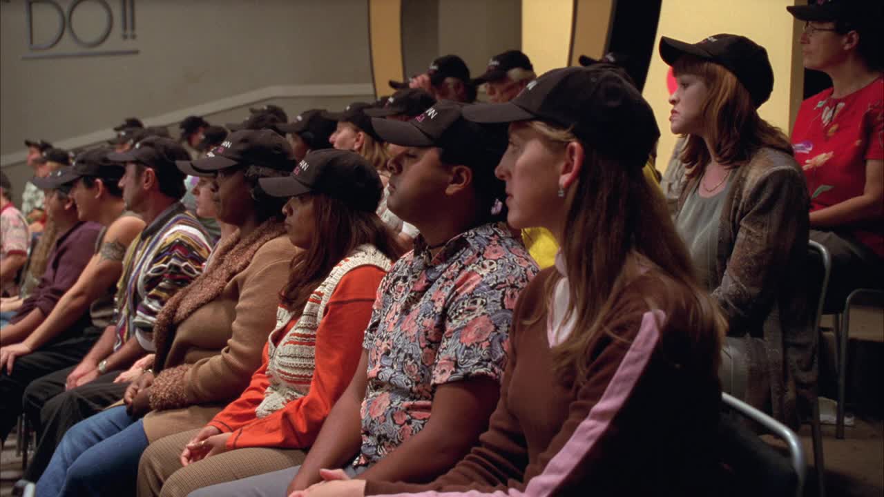 泛右向左的坐着的人或演播室观众戴着相配的帽子或棒球风格的帽子。人们在观看电视或谈话节目拍摄时，会做出反应并鼓掌。可能是励志演说家。视频下载