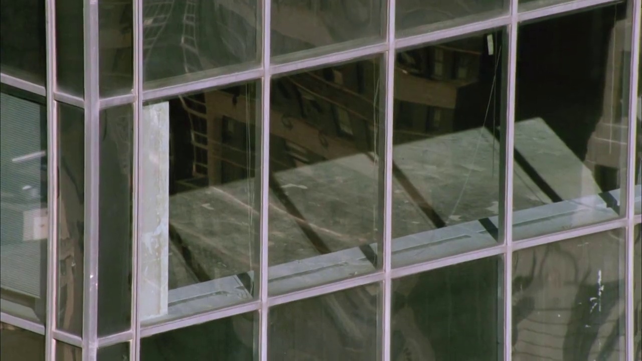 在办公大楼或摩天大楼的玻璃窗旁进行空中飞行或盘旋。视频下载