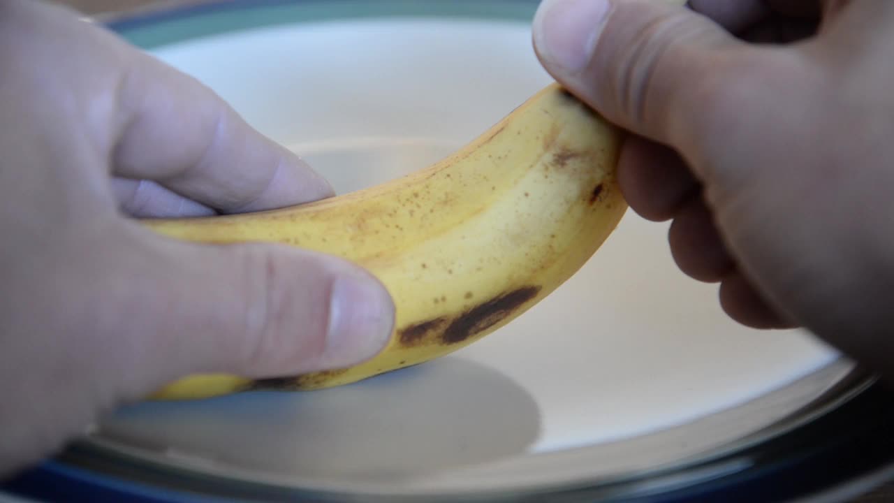 用手剥盘子里的香蕉水果视频素材
