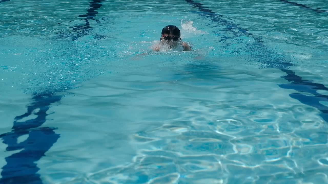 慢动作镜头年轻的混合亚洲十几岁的男孩游泳在游泳池蝶泳，儿童运动视频下载