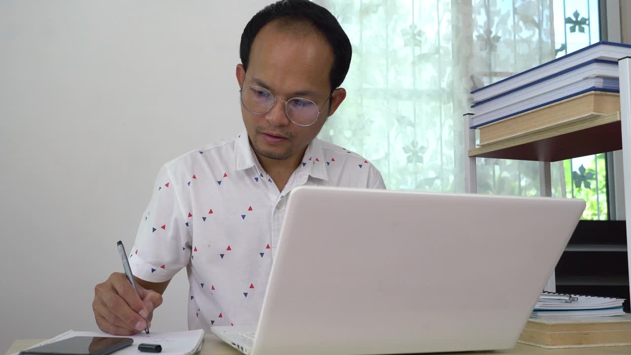 在家工作的亚洲人与办公室联系。视频素材