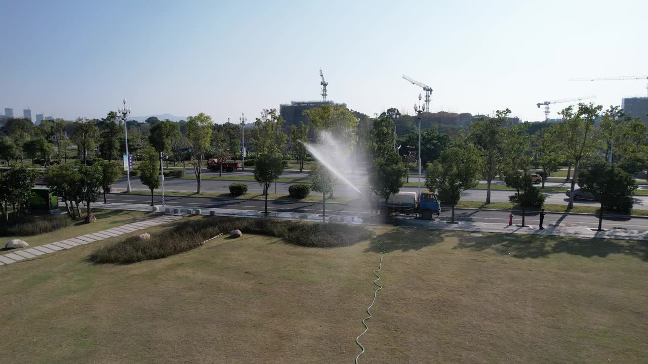鸟瞰图的花园浇水车正在浇灌花园的草视频下载