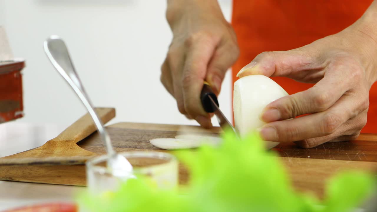 用手用刀切洋葱作为配料。视频素材