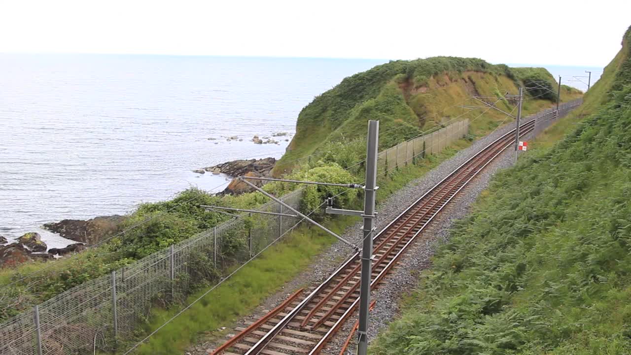 在爱尔兰海岸的石头岩石山徒步旅行路径。布雷，格雷斯通:爱尔兰格雷斯通铁路与海滨的美丽风景视频下载