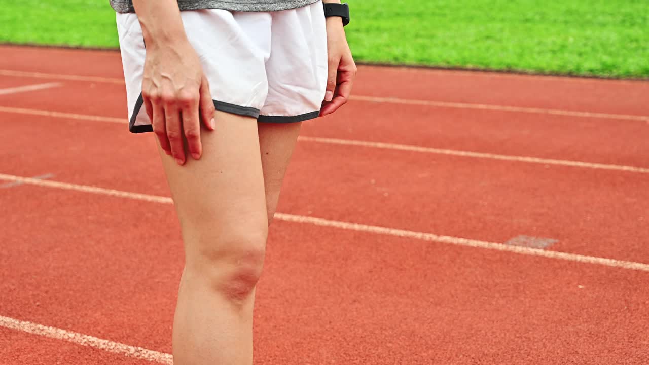 特写女跑步者抱碰膝盖引起的膝盖疼痛。视频下载