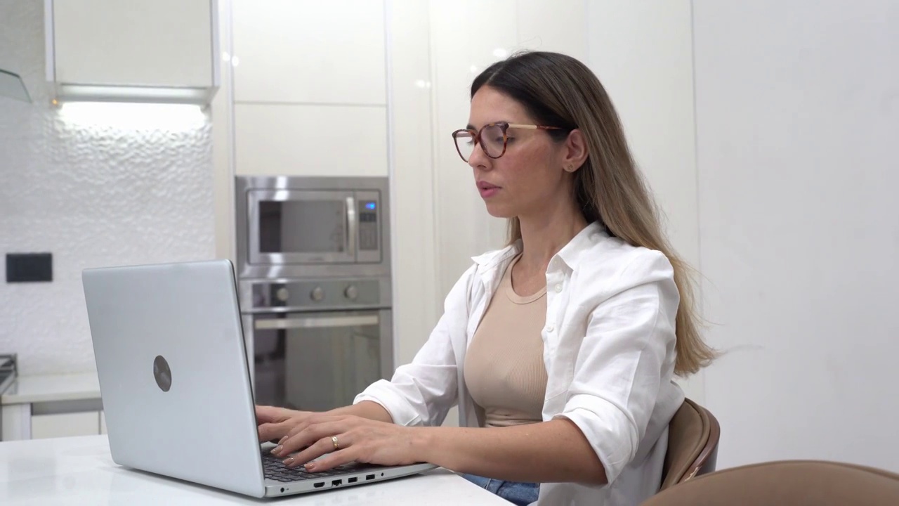 一个疲惫的中年妇女在家里用笔记本电脑工作视频素材