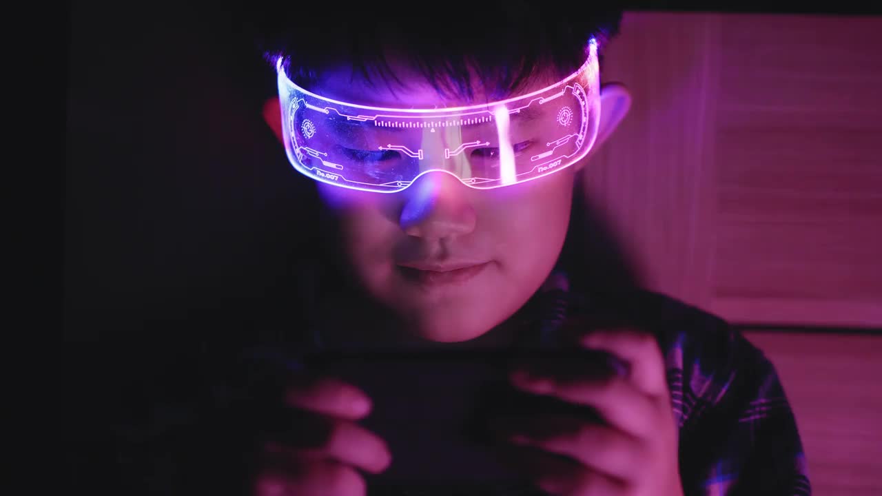 亚洲儿童戴着现代眼镜玩游戏。视频下载