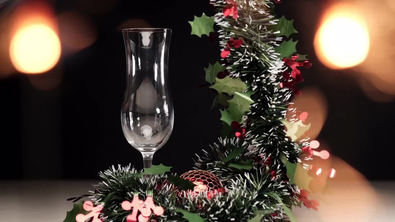 倒入香槟在长笛与圣诞花环装饰和烟花爆竹灯光视频下载
