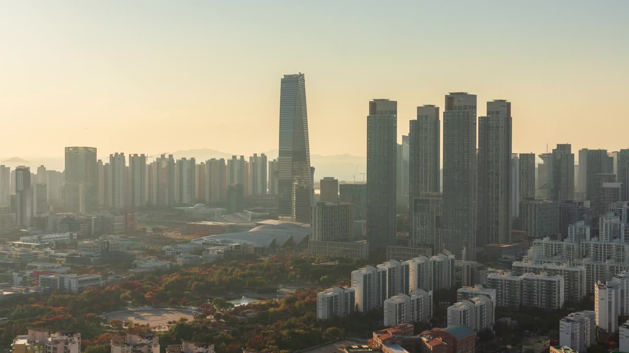 白天——韩国仁川延寿区松岛国际商务区东北亚贸易大厦、综合开发和公园的日落视频下载