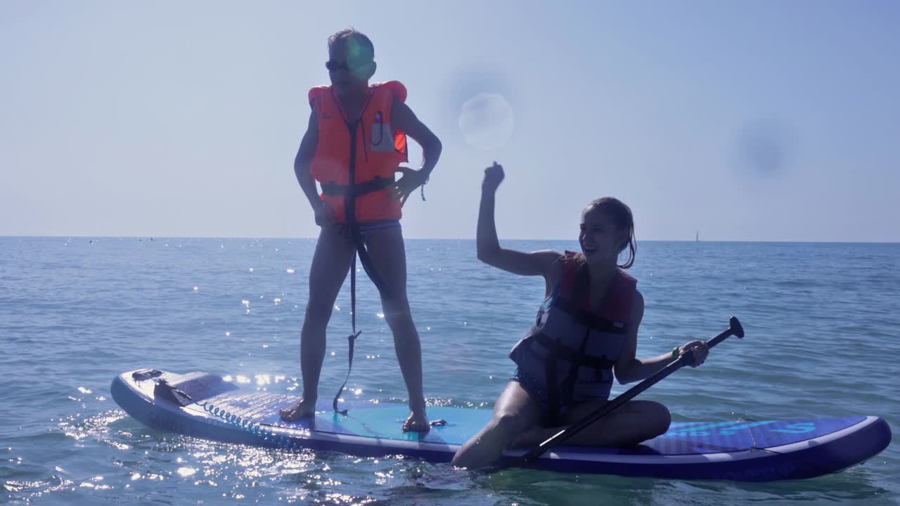 孩子们从SUP冲浪板跳入大海视频下载