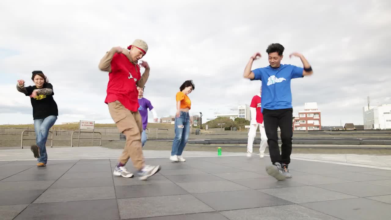 年轻人和他们的老师在海滩边的公园里练习街舞。视频下载