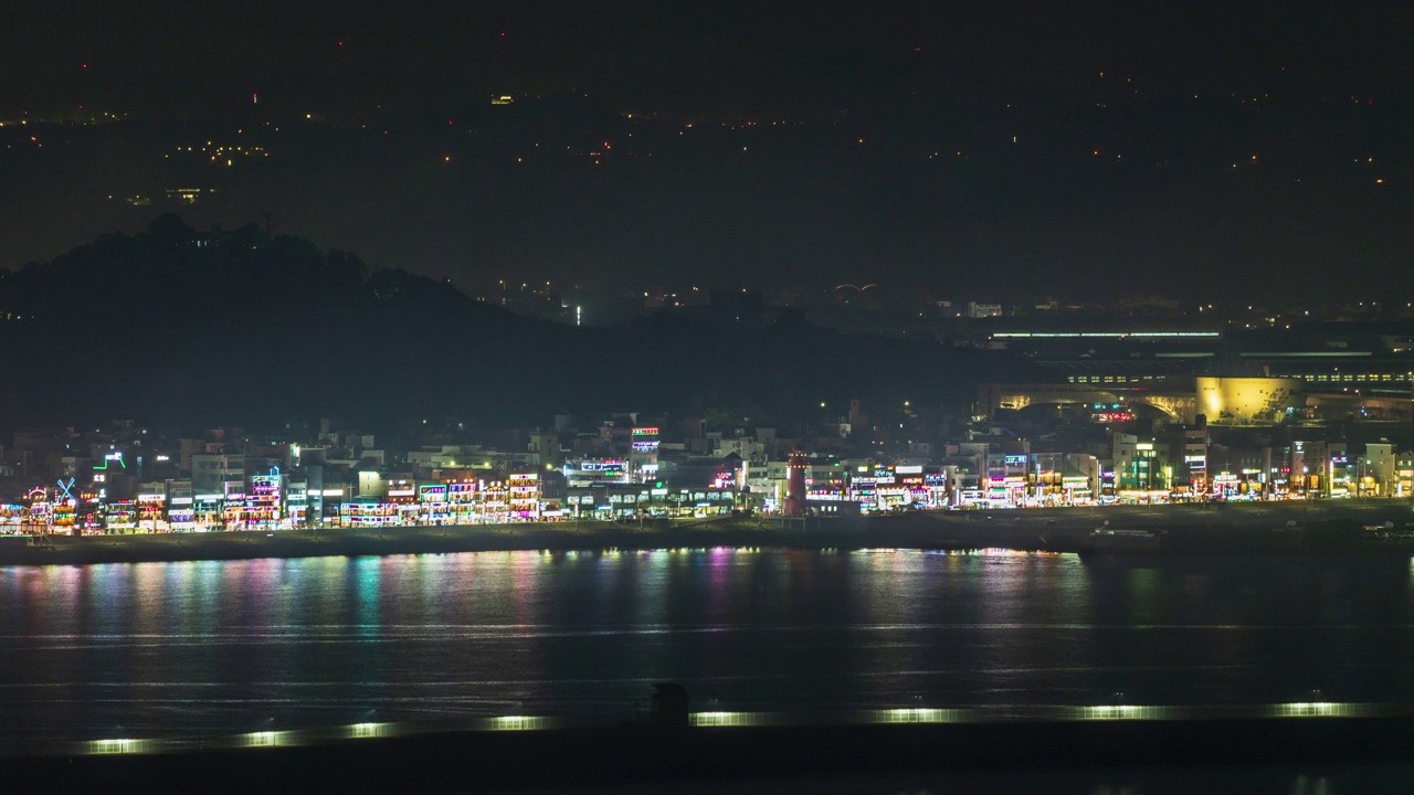 夜晚——韩国京畿道始兴市黄海附近的大岛码头的大岛红色灯塔和美食街视频下载