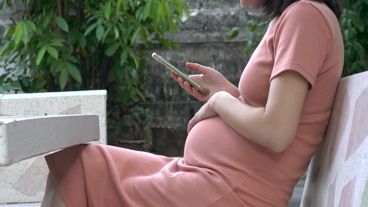 女性等待她的孩子，亚洲孕妇看她的超声波扫描照片手机视频下载