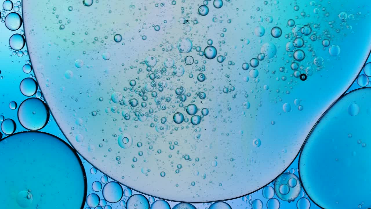 在蓝色背景上移动的液体气泡的完整框架。视频素材