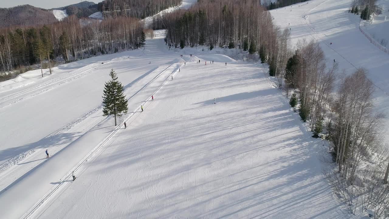 在斜坡上移动的滑雪升降机的鸟瞰图。乘滑雪缆车上山的滑雪者视频素材