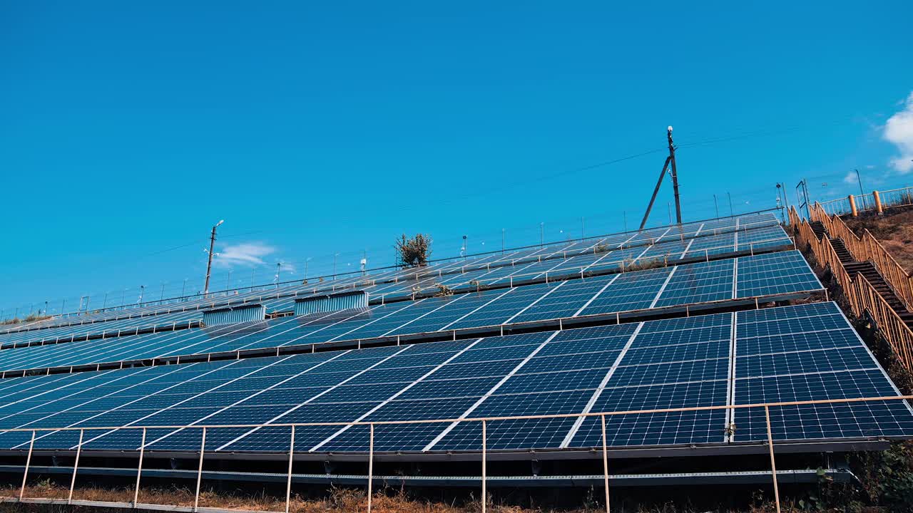 替代能源。蓝色太阳能电池板从太阳获得清洁的生态能源。现代太阳能农场在晴朗的天空背景。视频素材