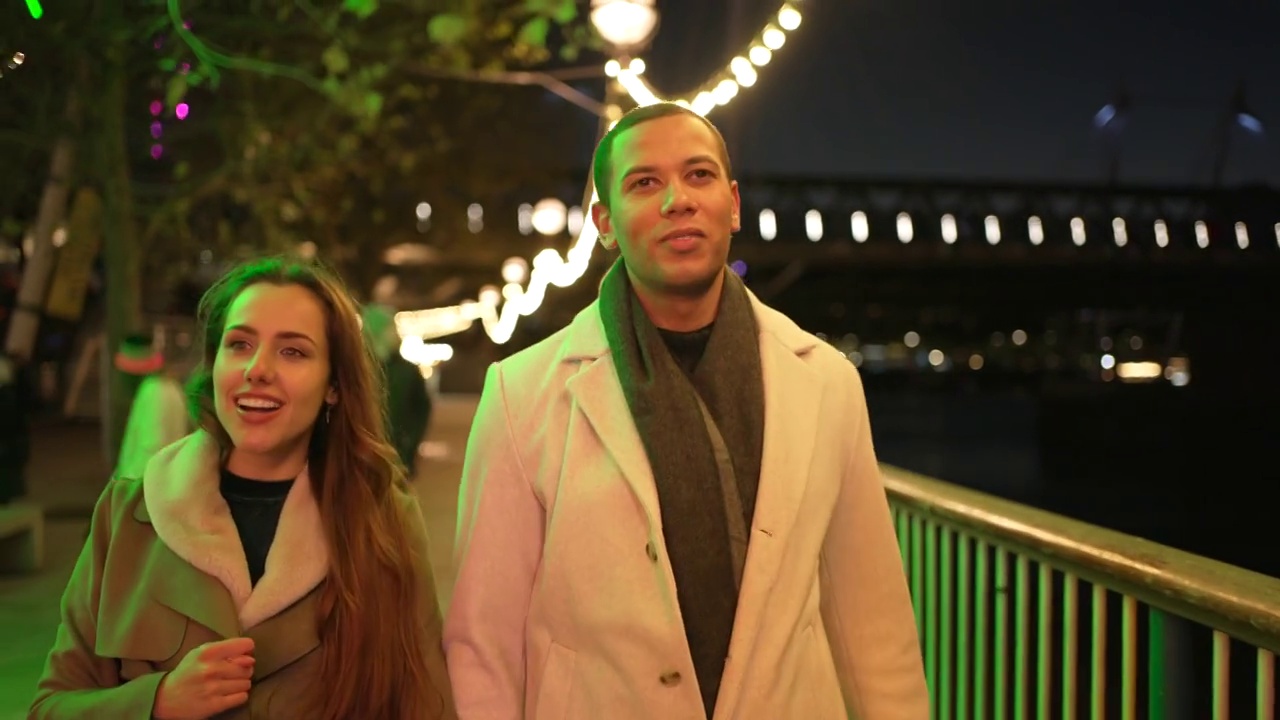 一对年轻夫妇走在夜晚的城市里视频下载