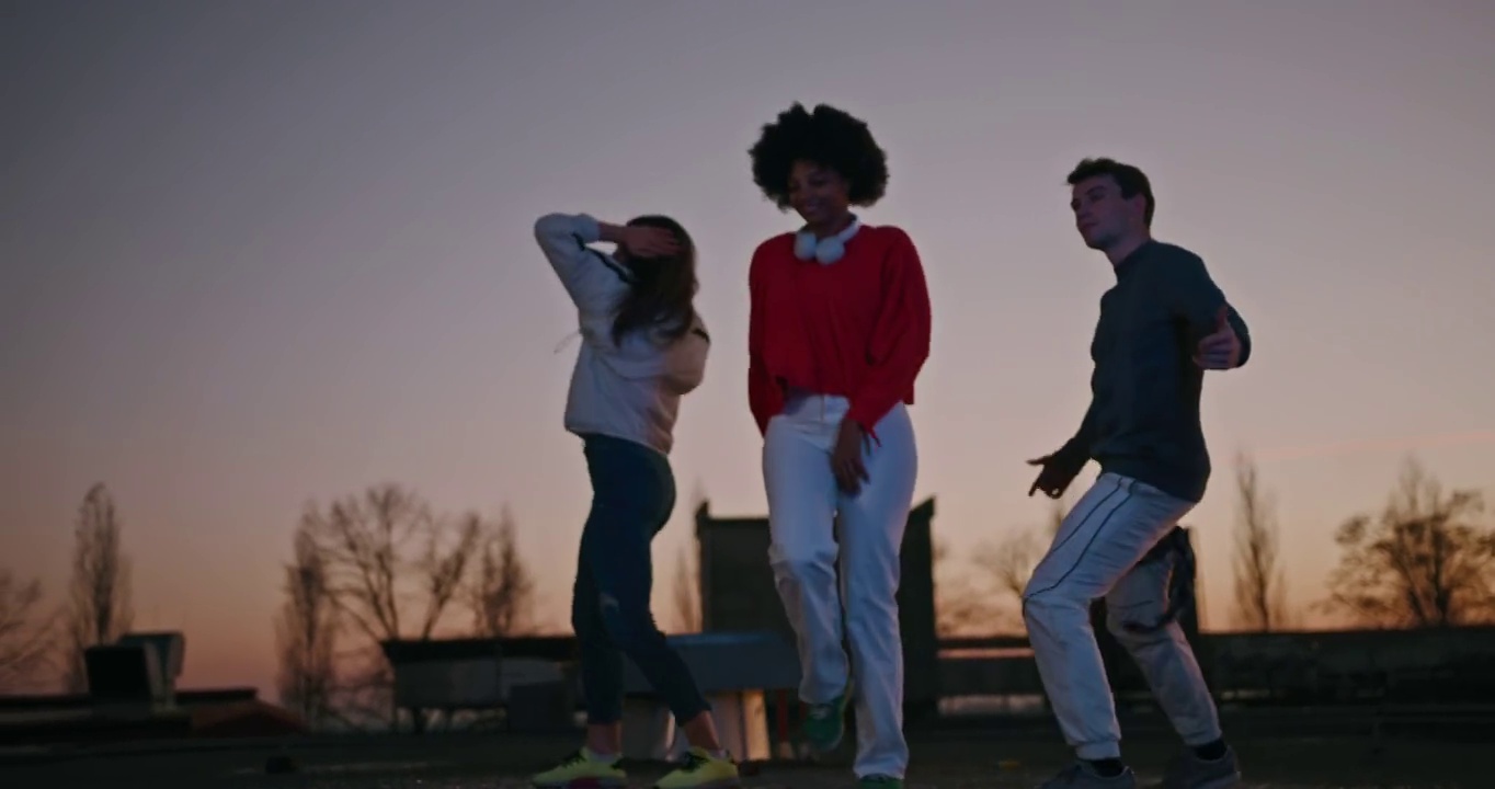 三个年轻的朋友在街上跳舞视频素材