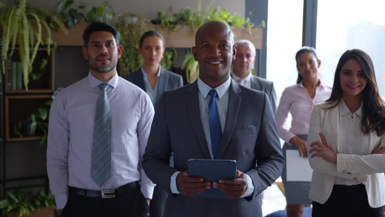 办公室里多元化的业务团队站在他的黑人男性CEO身后，所有人面对镜头微笑视频素材