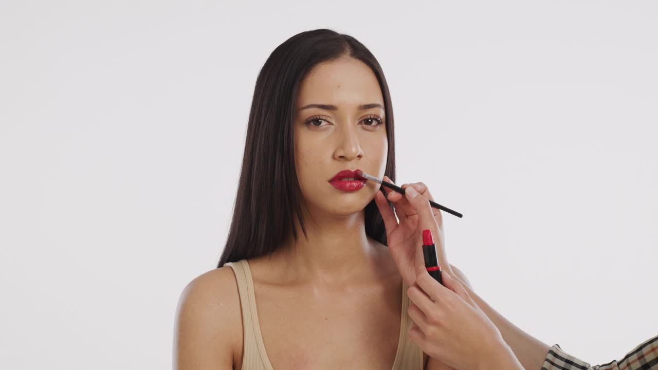 一个美丽的年轻女子在白色背景下化妆的4k视频片段视频下载