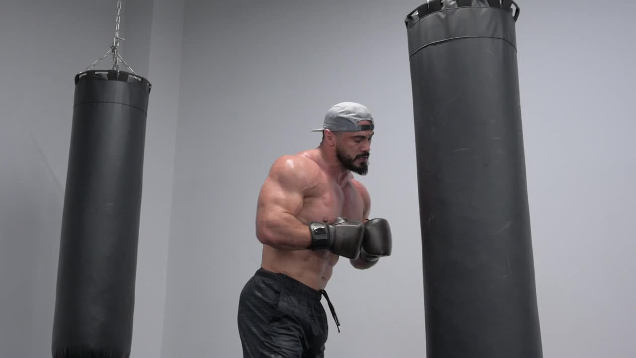 疲惫的强壮的拳击男子在沉重的训练后脱下手套视频下载