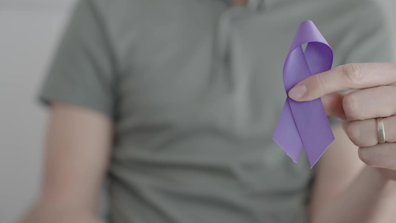 手握紫色丝带，老年痴呆症，胰腺癌，癫痫意识，世界癌症日视频下载