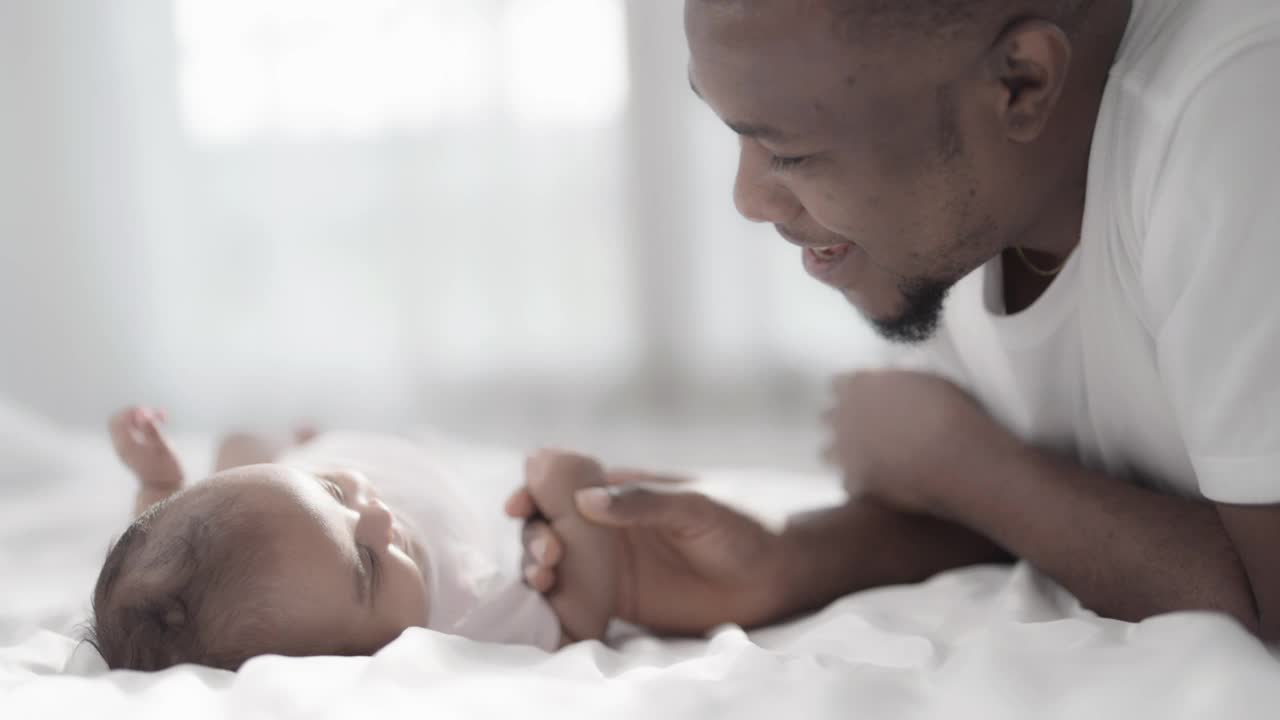 非洲父亲和孩子躺在床上视频素材