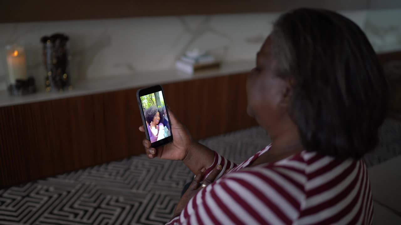 一名资深女性正在家里用智能手机进行视频通话视频素材