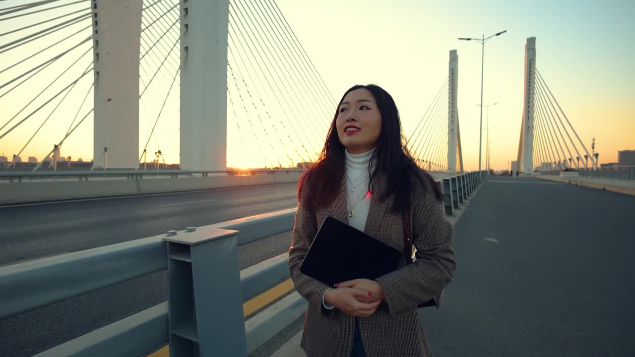 日落时分，一个女人走在桥上视频素材