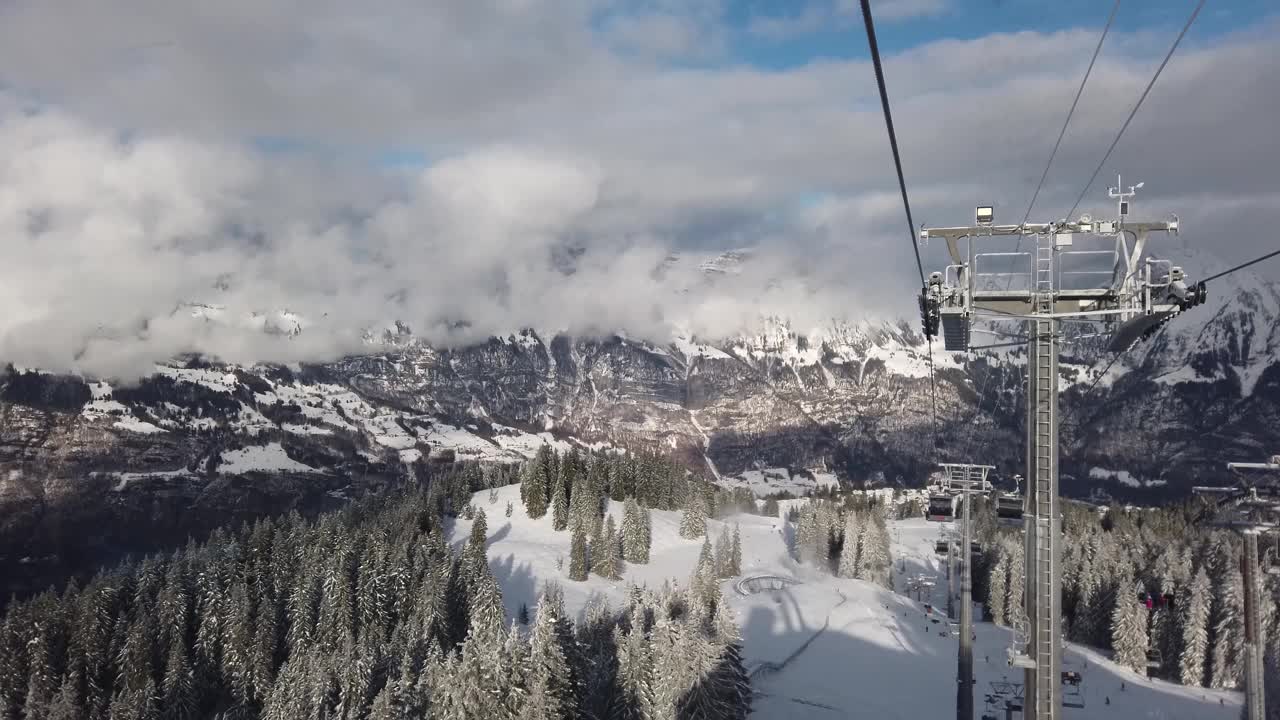 瑞士山区度假胜地Flumserber的滑雪椅升降机视图。白雪覆盖的山脉，阳光灿烂的日子，无法辨认的游客，实时的。视频素材